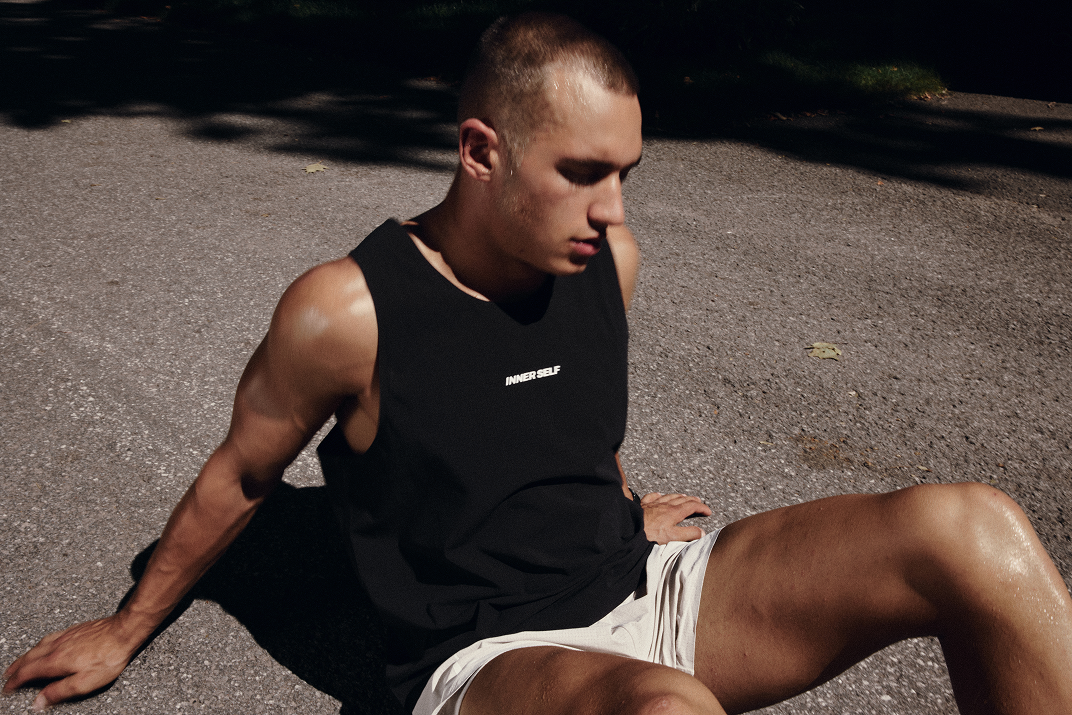 Two-panel photograph of models seated outdoors in black running tank tops