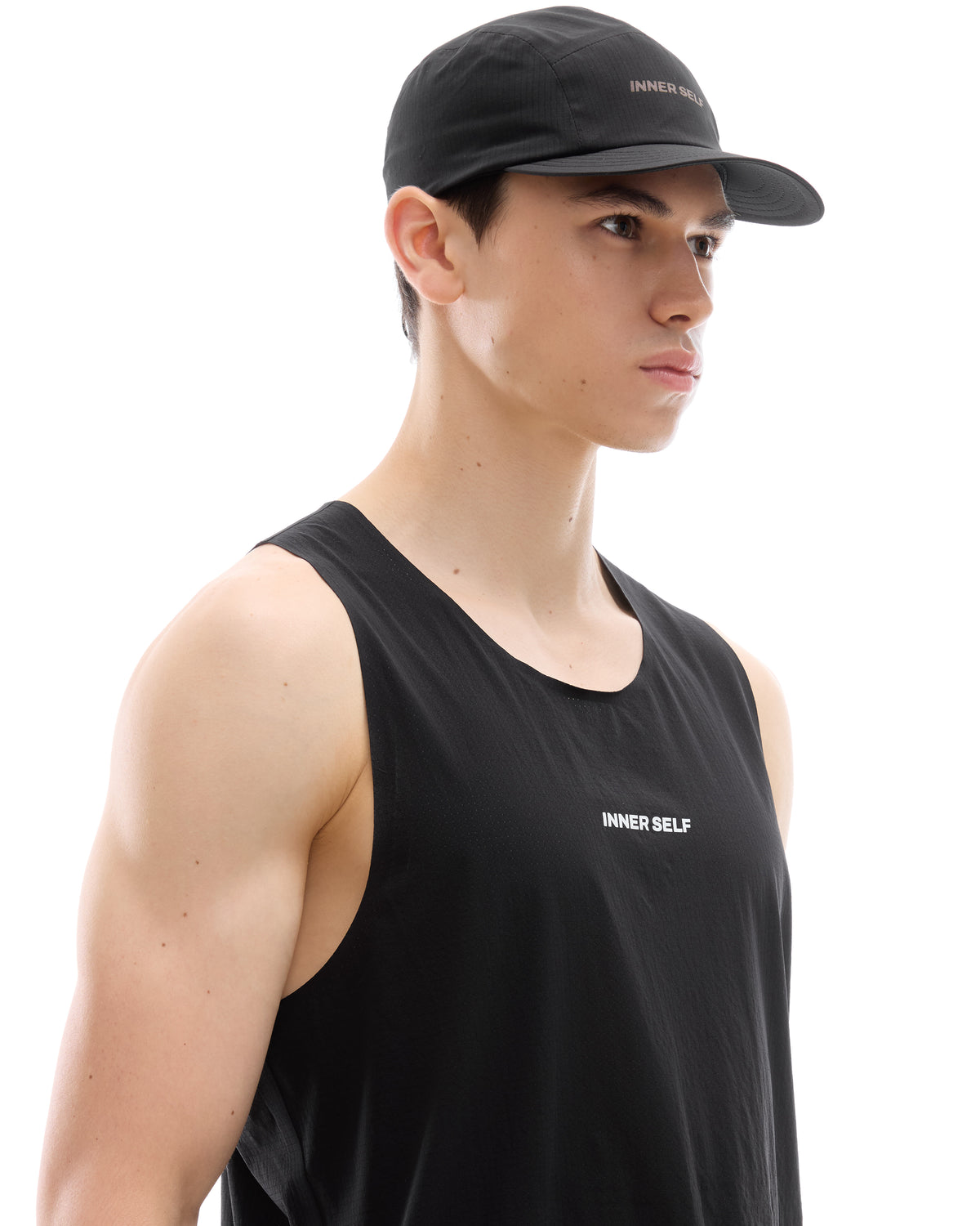 INNER SELF Performance Cap in black — three-quarter view on male model