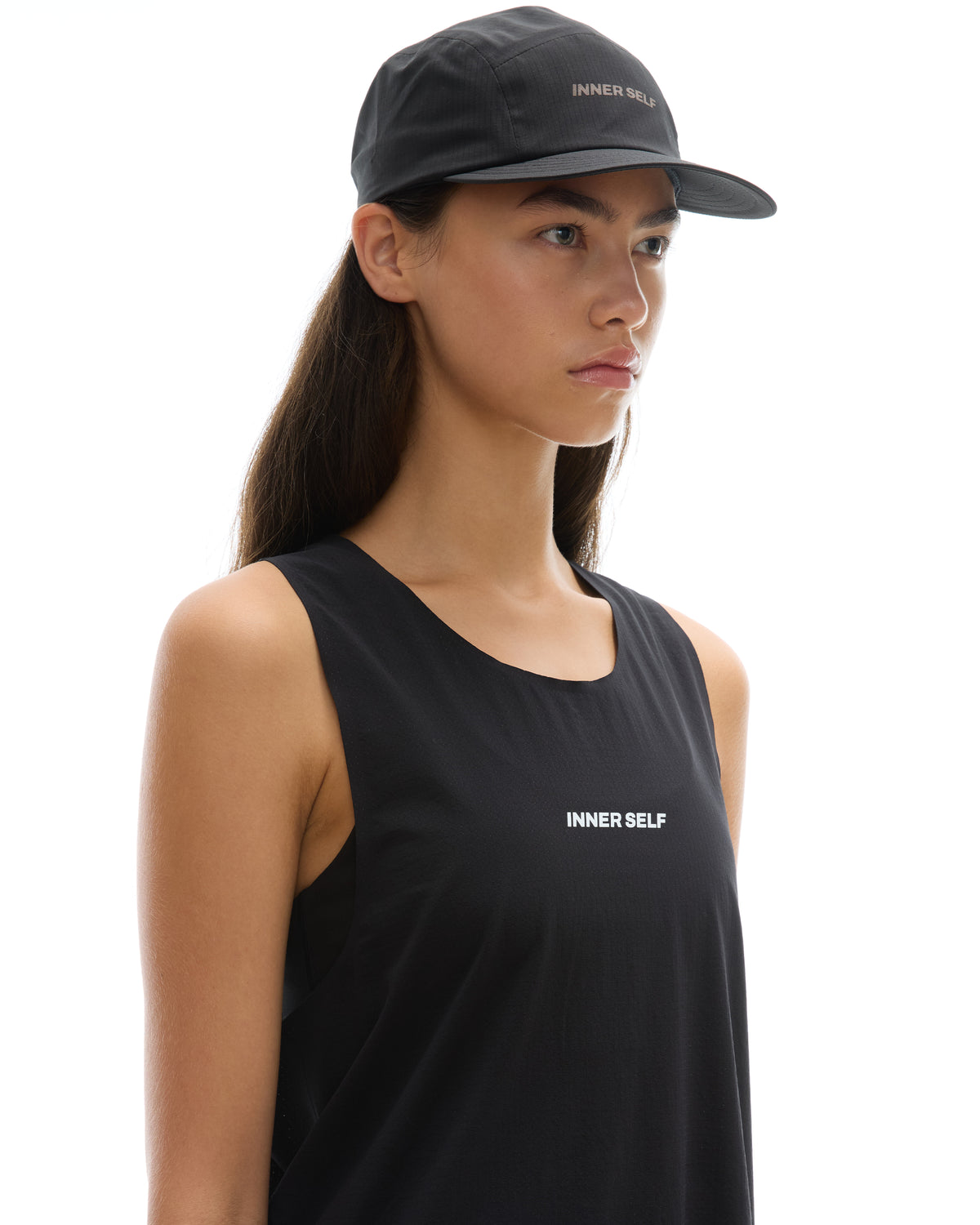 INNER SELF Performance Cap in black — three-quarter view on female model