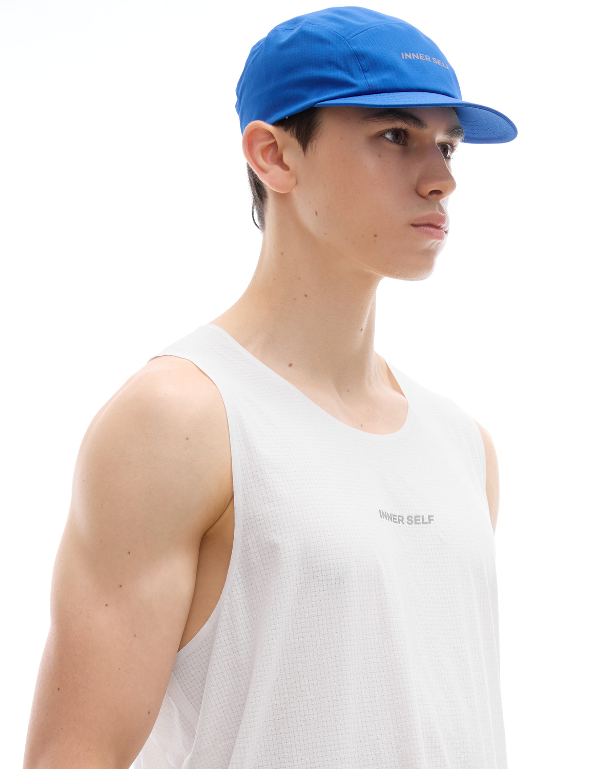 INNER SELF Performance Cap in blue — three-quarter view on male model